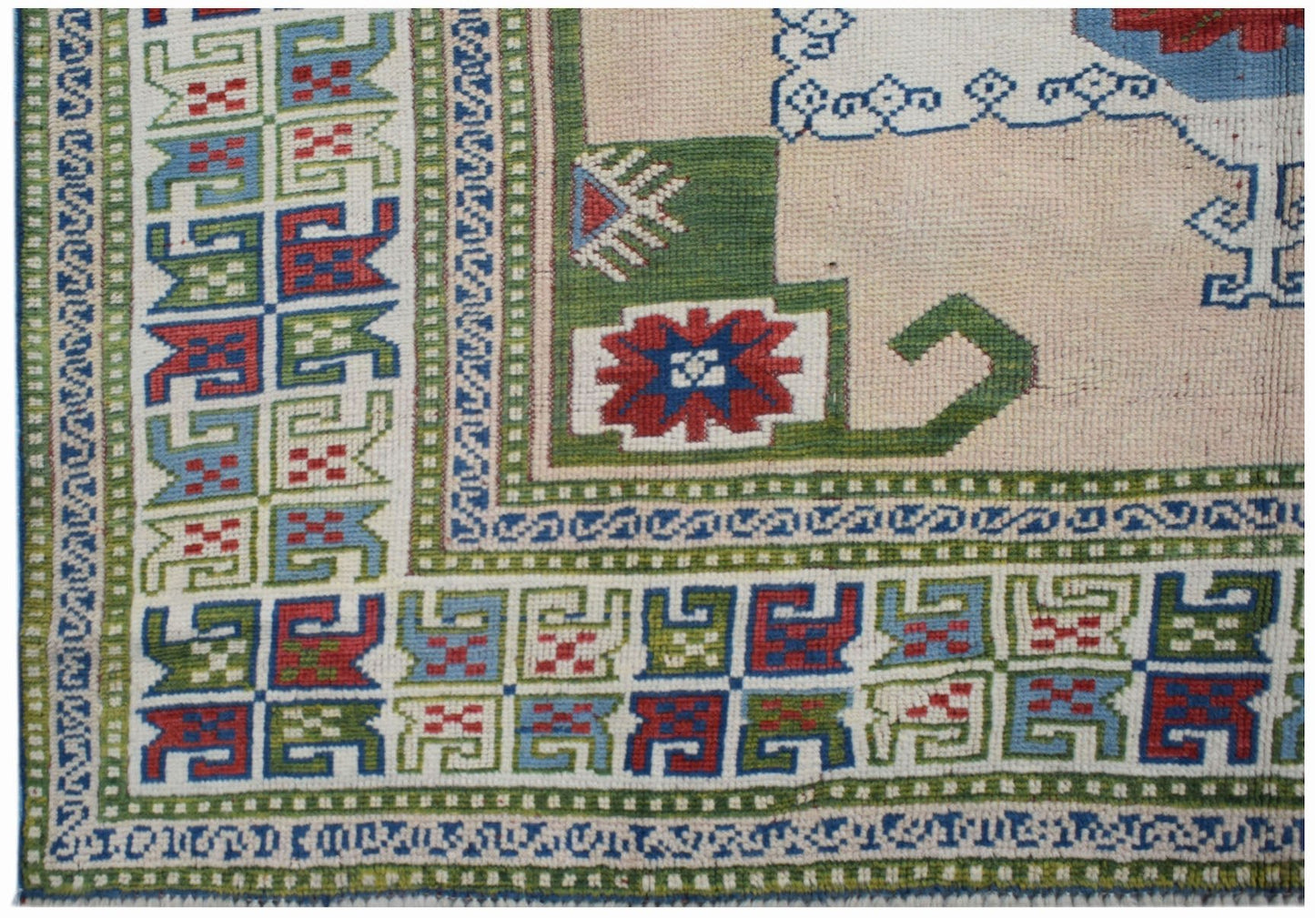A vintage Turkish Oushak rug featuring a geometric border and a traditional Anatolian pattern.