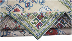A vintage Turkish Oushak rug featuring a traditional geometric pattern in blue, red, and green.