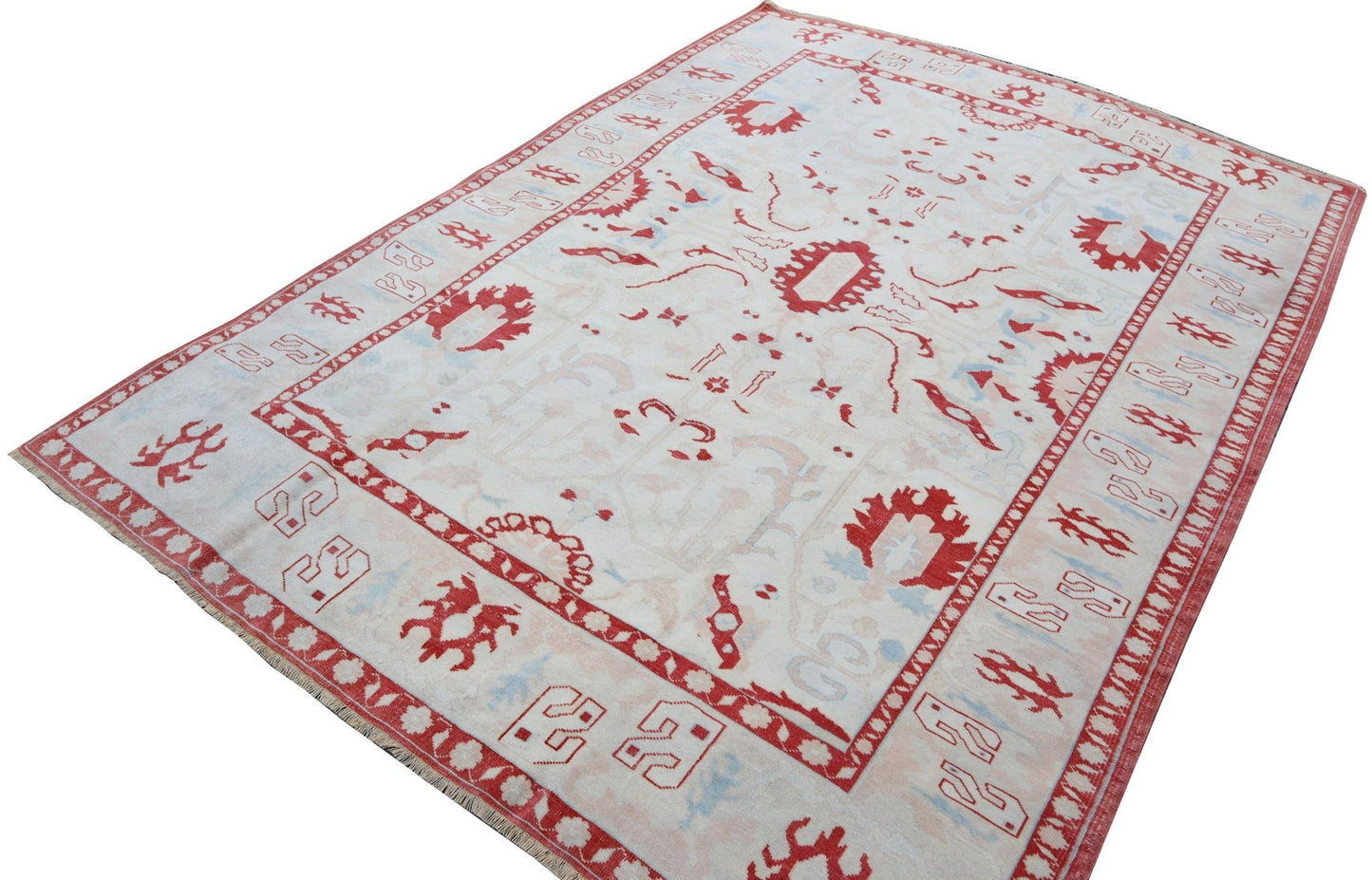 A vintage handmade Turkish Oushak rug featuring a traditional red and light blue pattern.