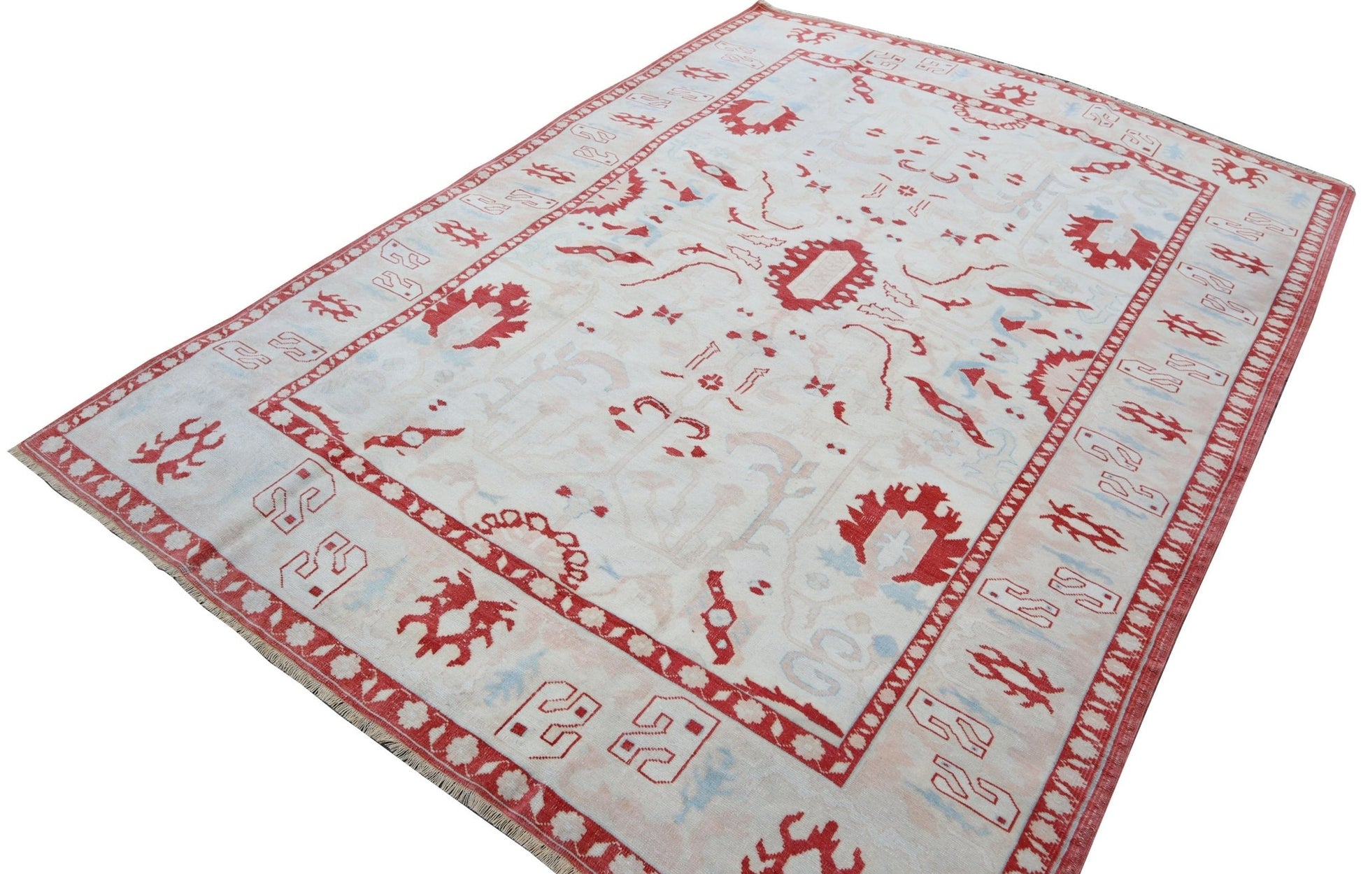 A vintage handmade Turkish Oushak rug featuring a traditional red and light blue pattern.