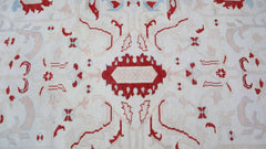 A vintage Turkish Oushak rug featuring a traditional red and cream geometric pattern.