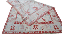 A vintage handmade Turkish Oushak rug featuring a traditional red and white geometric pattern.
