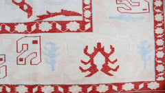 A vintage Turkish Oushak rug featuring a cream field with red geometric motifs and blue accents.