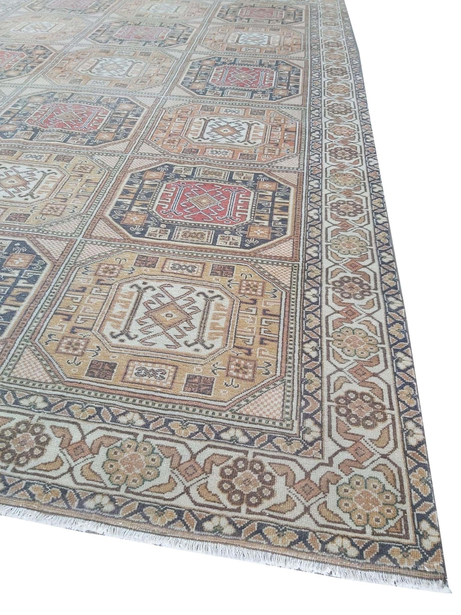 A vintage Turkish Oushak rug featuring a geometric grid pattern in muted earth tones.