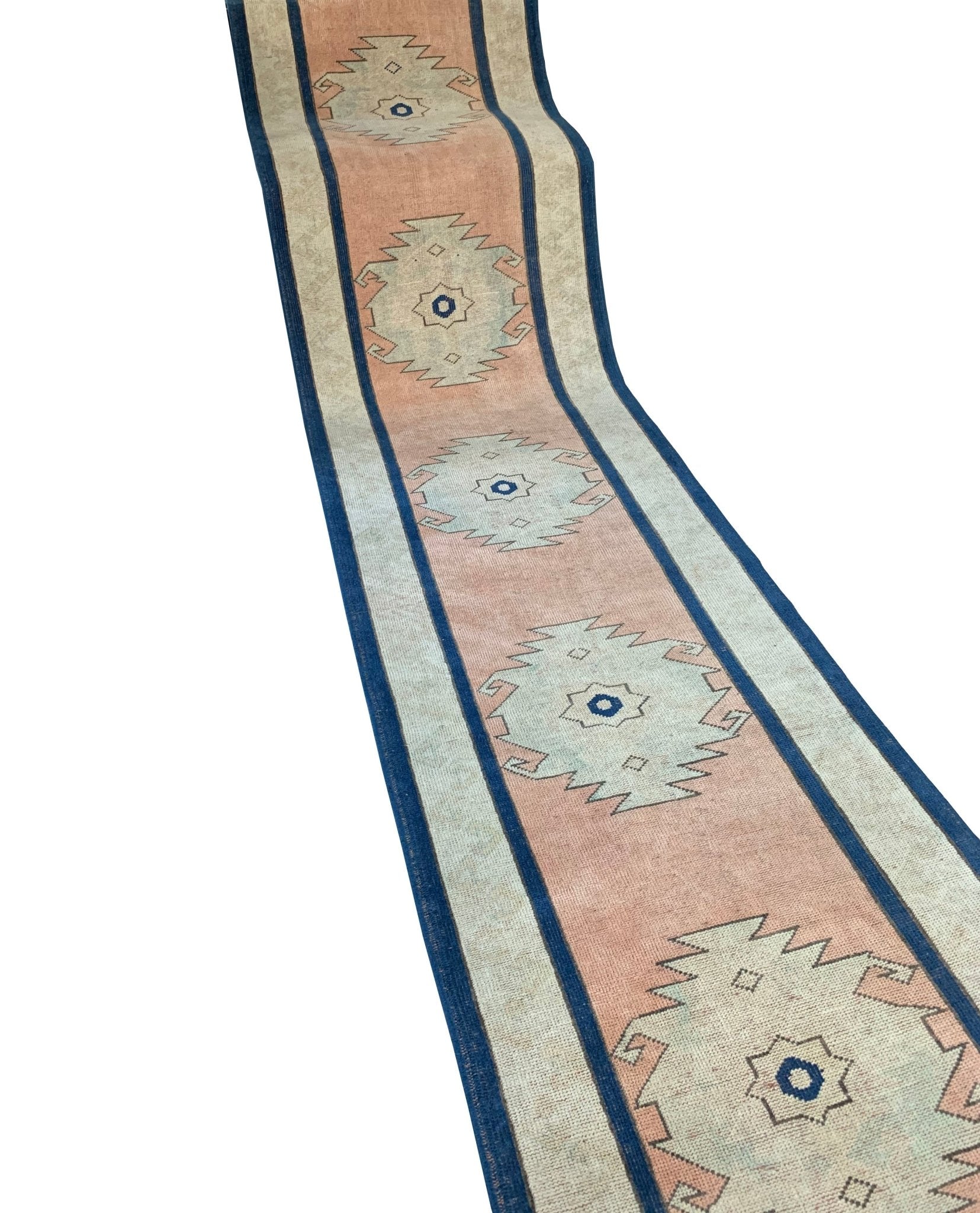 A vintage Turkish Oushak runner featuring tribal motifs in pink, blue, and cream tones.