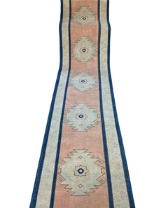 A vintage Turkish Oushak runner featuring tribal motifs in soft pink and blue tones.