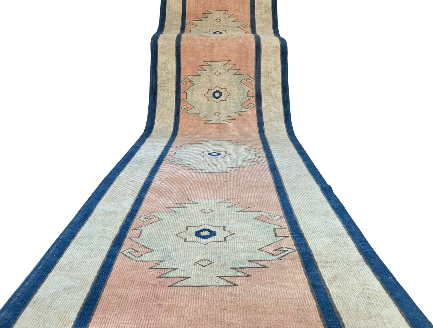 A vintage Turkish Oushak runner featuring tribal motifs in soft pink, blue, and cream tones.