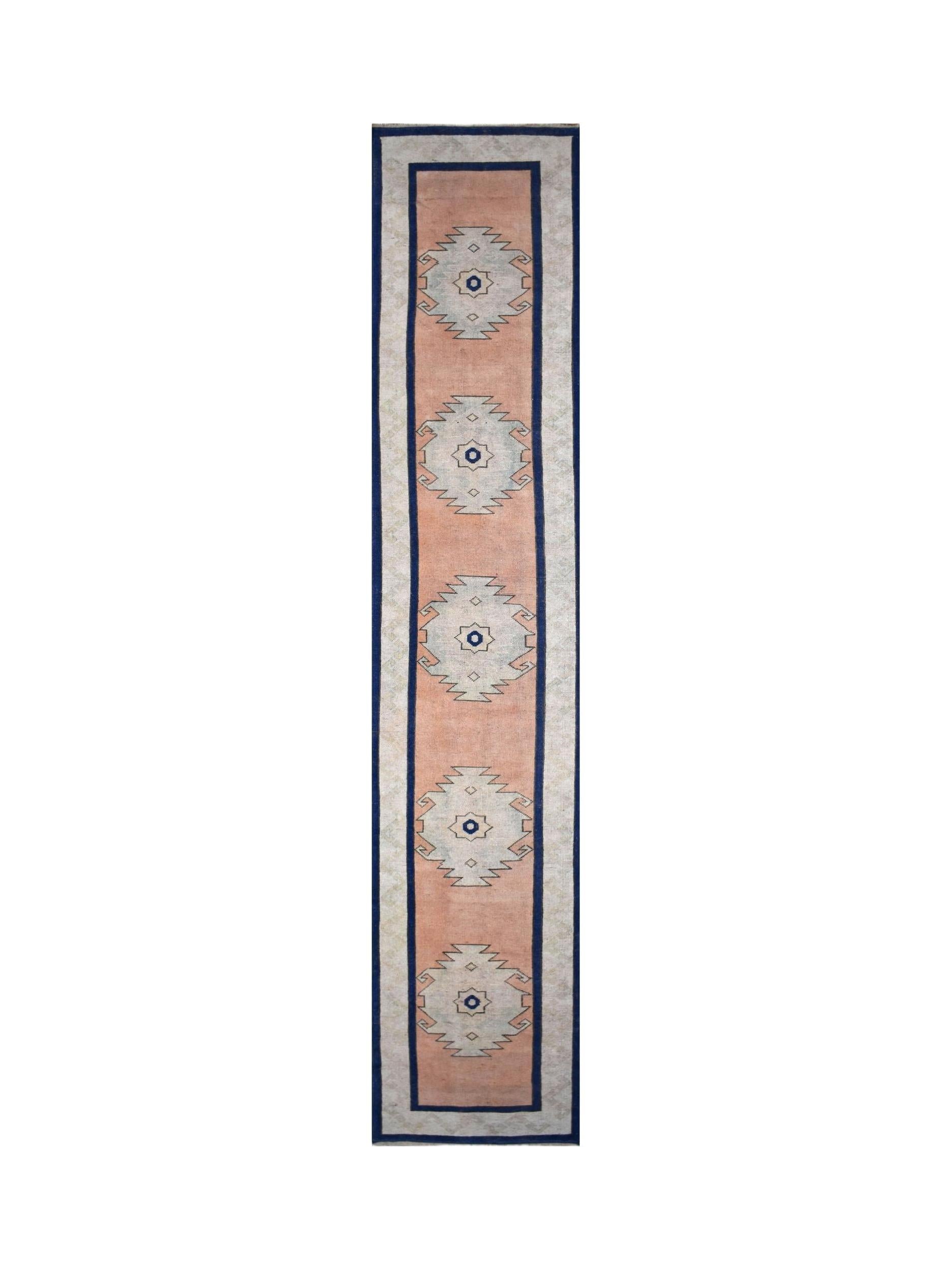 A vintage Turkish Oushak runner featuring five geometric medallions on a peach field.