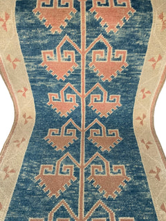 A vintage Turkish Oushak runner featuring pink geometric motifs on a blue field with cream borders.