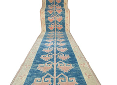 A vintage Turkish Oushak runner featuring a blue field with repeating pink tribal motifs.