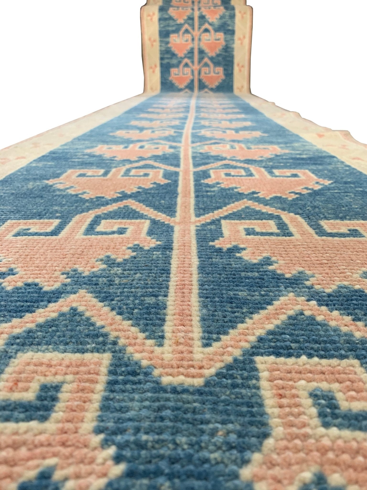 A vintage Turkish Oushak runner featuring pink tribal motifs on a blue wool background.