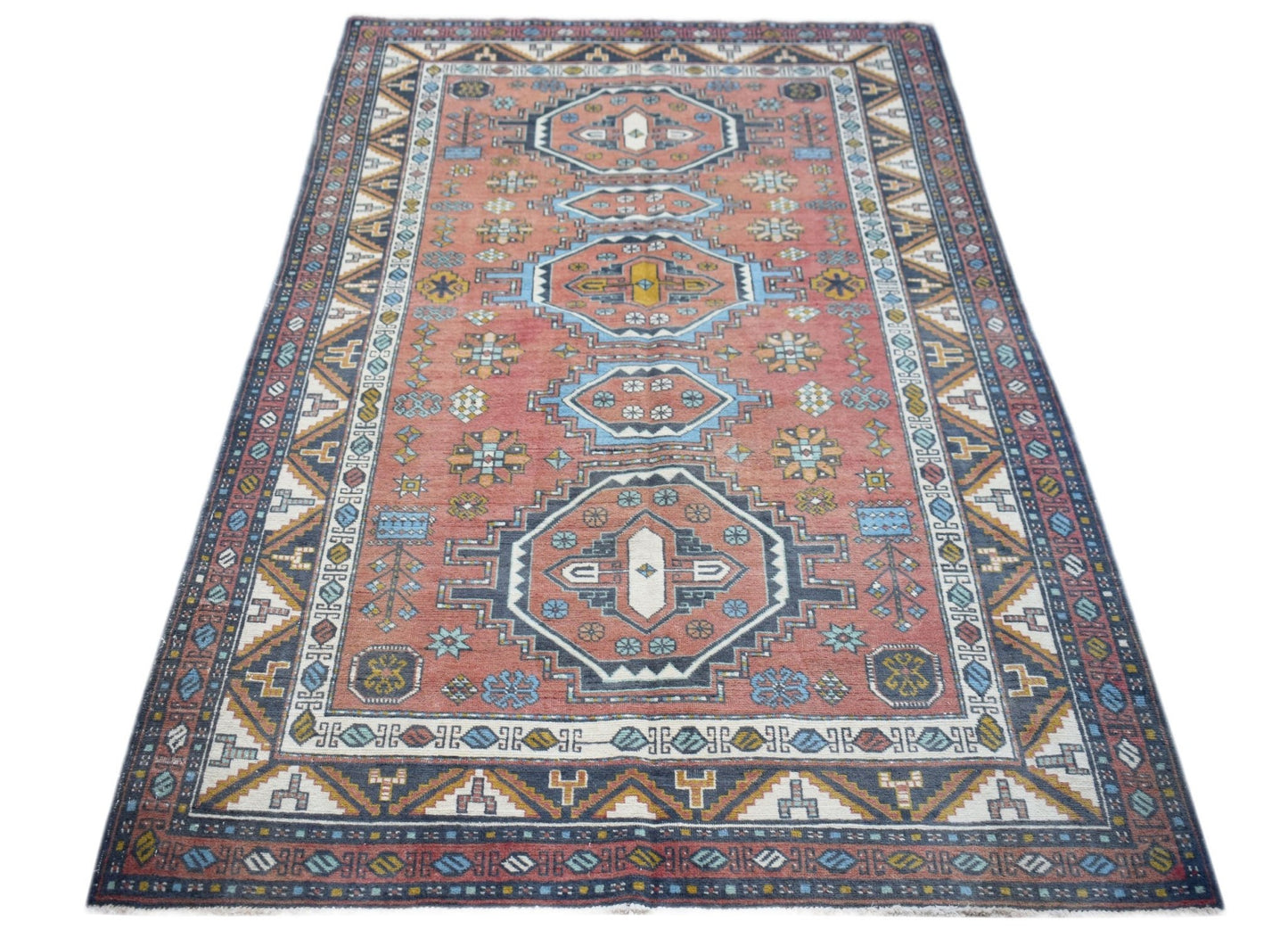 A vintage handwoven Turkish rug featuring a geometric medallion pattern in shades of red and blue.