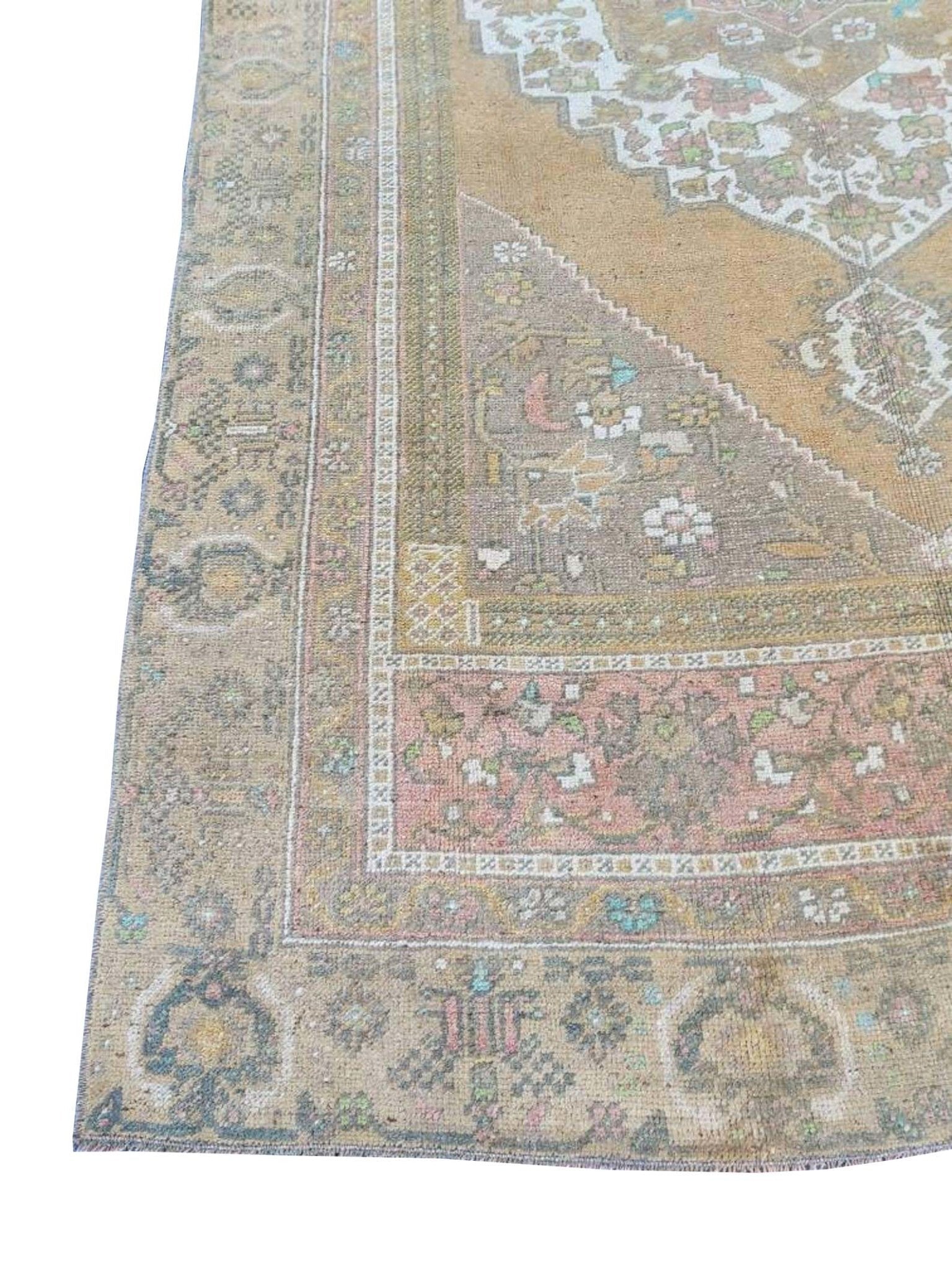 A vintage handmade Turkish wool rug featuring a faded geometric pattern in muted earth tones.