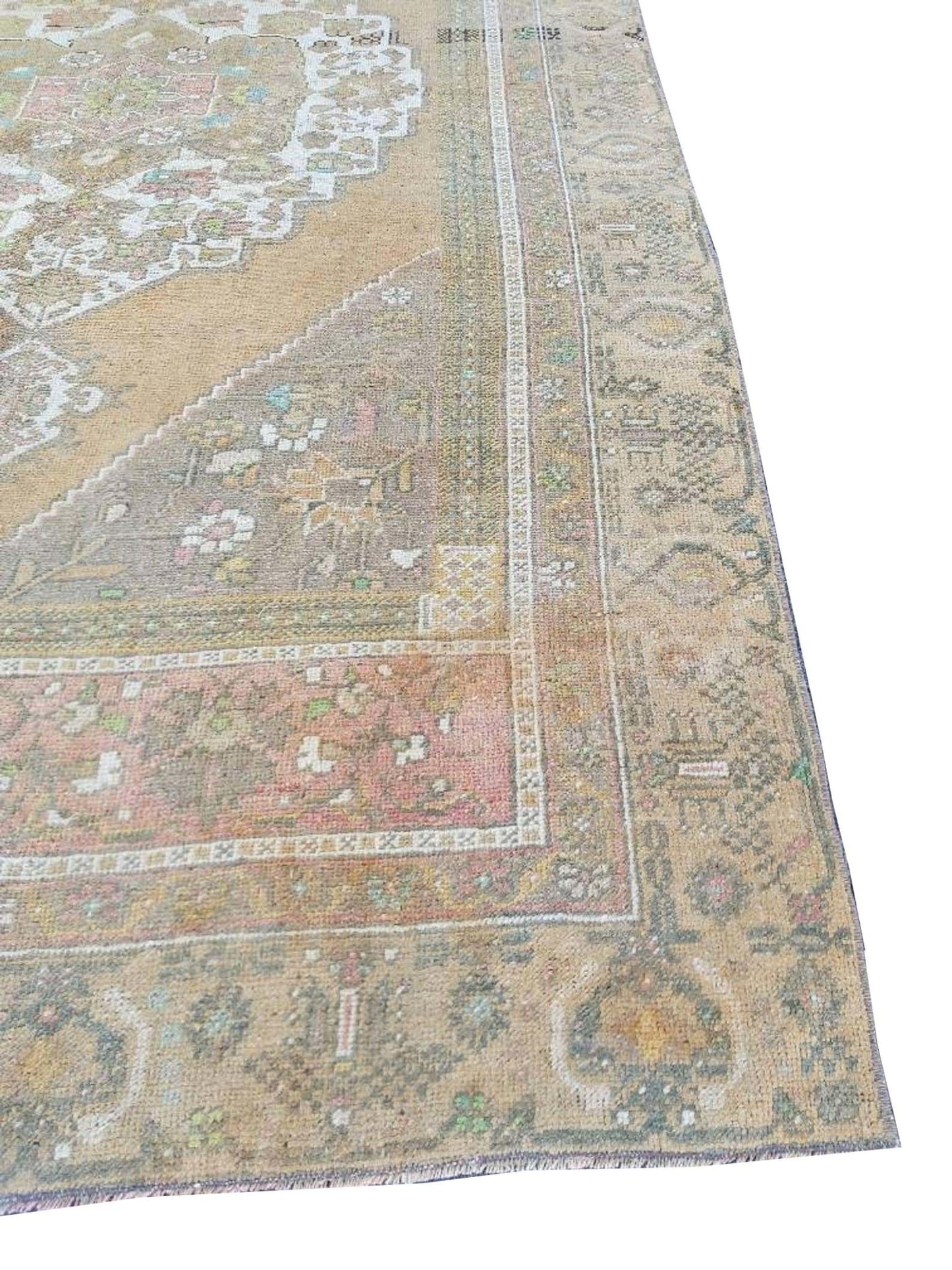 A vintage handmade Turkish wool rug featuring a faded geometric pattern in muted earth tones.
