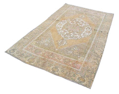 A vintage handmade Turkish wool rug featuring a faded medallion pattern in muted earth tones.