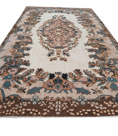 A vintage handmade Turkish Isparta rug featuring a floral medallion on a cream field with a dark border.