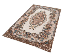 A vintage handmade Turkish Isparta rug featuring a floral central medallion and a dark brown border.