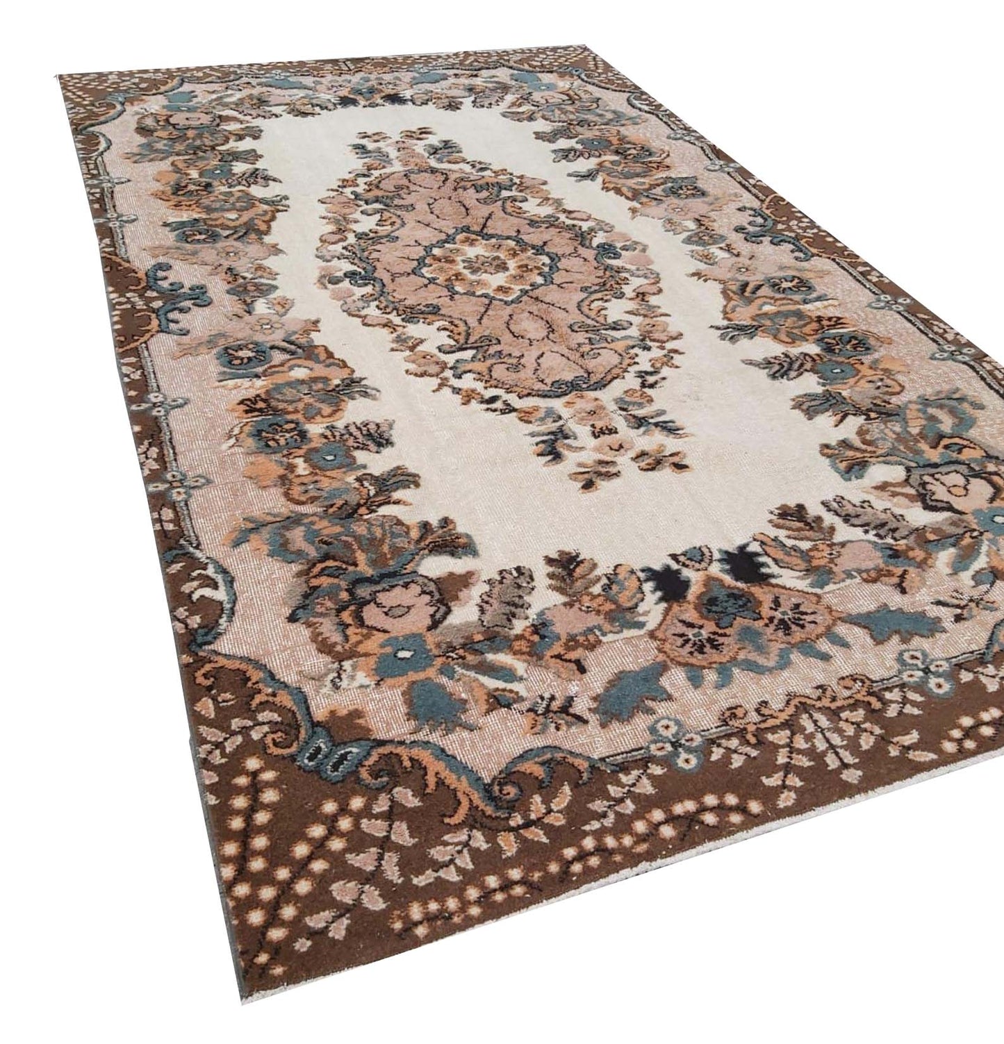 A vintage Turkish Isparta rug featuring a floral medallion on a cream field with a brown border.