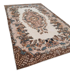 A vintage Turkish Isparta rug featuring a floral medallion on a cream field with a brown border.