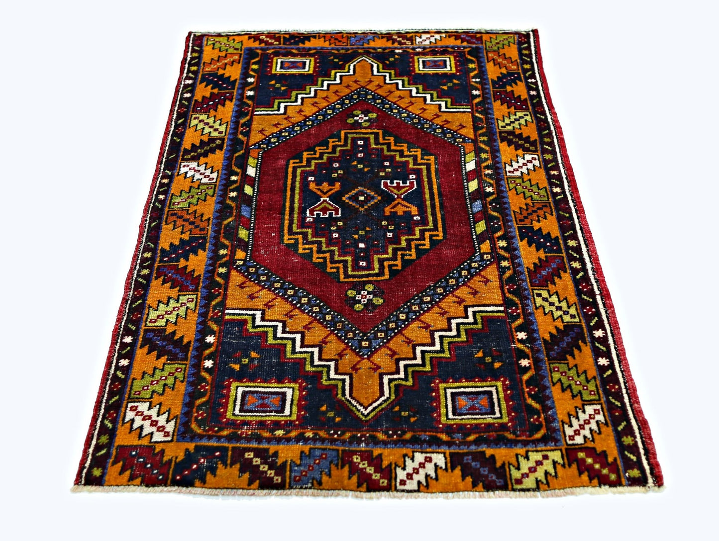 A vintage handmade Turkish Taspinar rug featuring a geometric diamond pattern in red and orange.