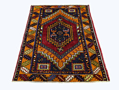 A vintage handmade Turkish Taspinar rug featuring a geometric diamond pattern in red and orange.