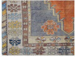 A vintage Turkish Taspinar rug featuring a geometric orange center and floral patterned borders.