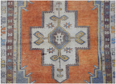 A vintage handwoven Turkish Taspinar rug featuring a geometric medallion on an orange field.
