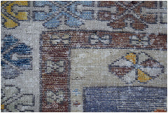 A vintage handwoven Turkish Taspinar rug featuring geometric patterns in blue, yellow, and brown.