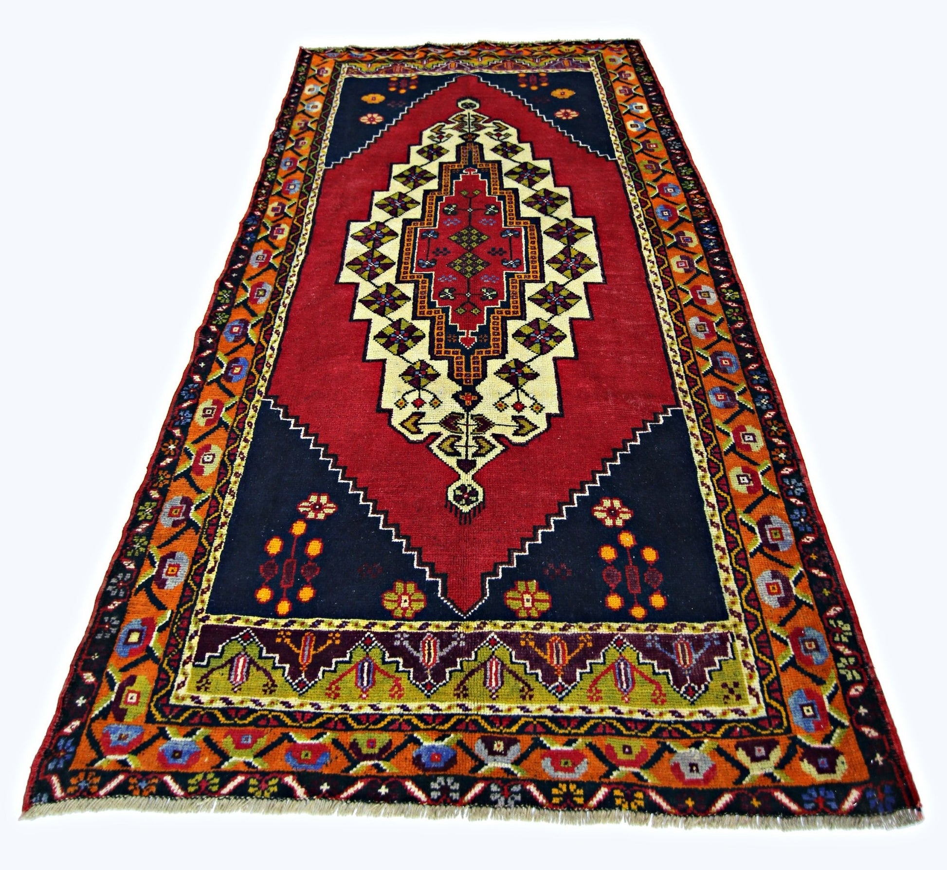 A vintage handmade Turkish Taspinar rug featuring a central geometric medallion on a red field.