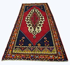 A vintage handmade Turkish Taspinar rug featuring a central geometric medallion on a red field.
