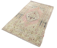 A vintage handmade Turkish Taspinar rug featuring soft pink and beige geometric patterns.