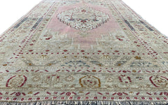 A vintage handmade Turkish Taspinar rug featuring soft pink tones and geometric patterns.