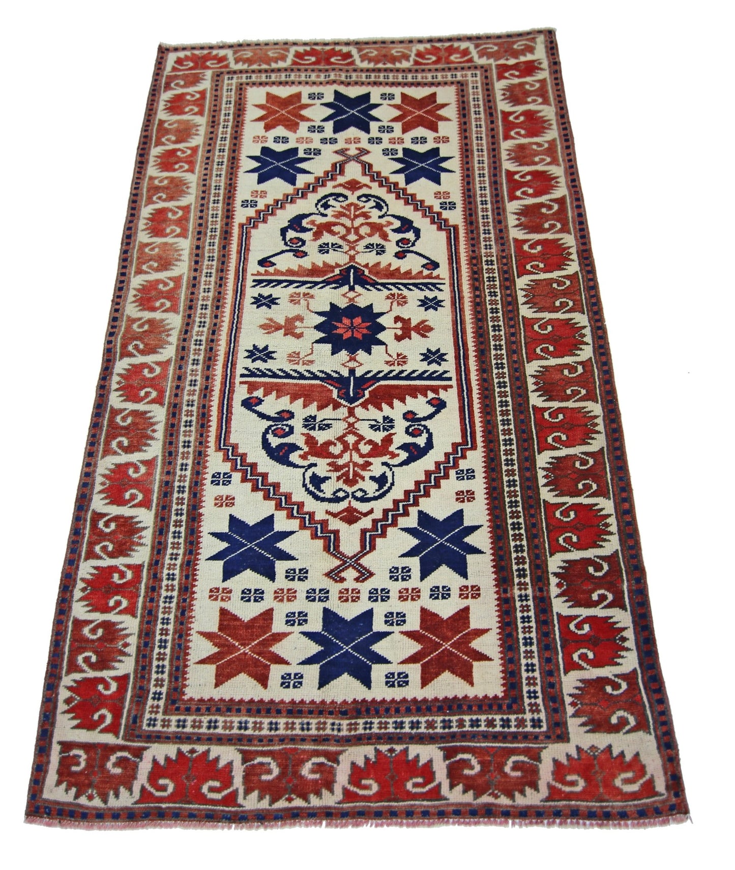A vintage handmade Turkish wool rug featuring a geometric star pattern in red, blue, and cream.
