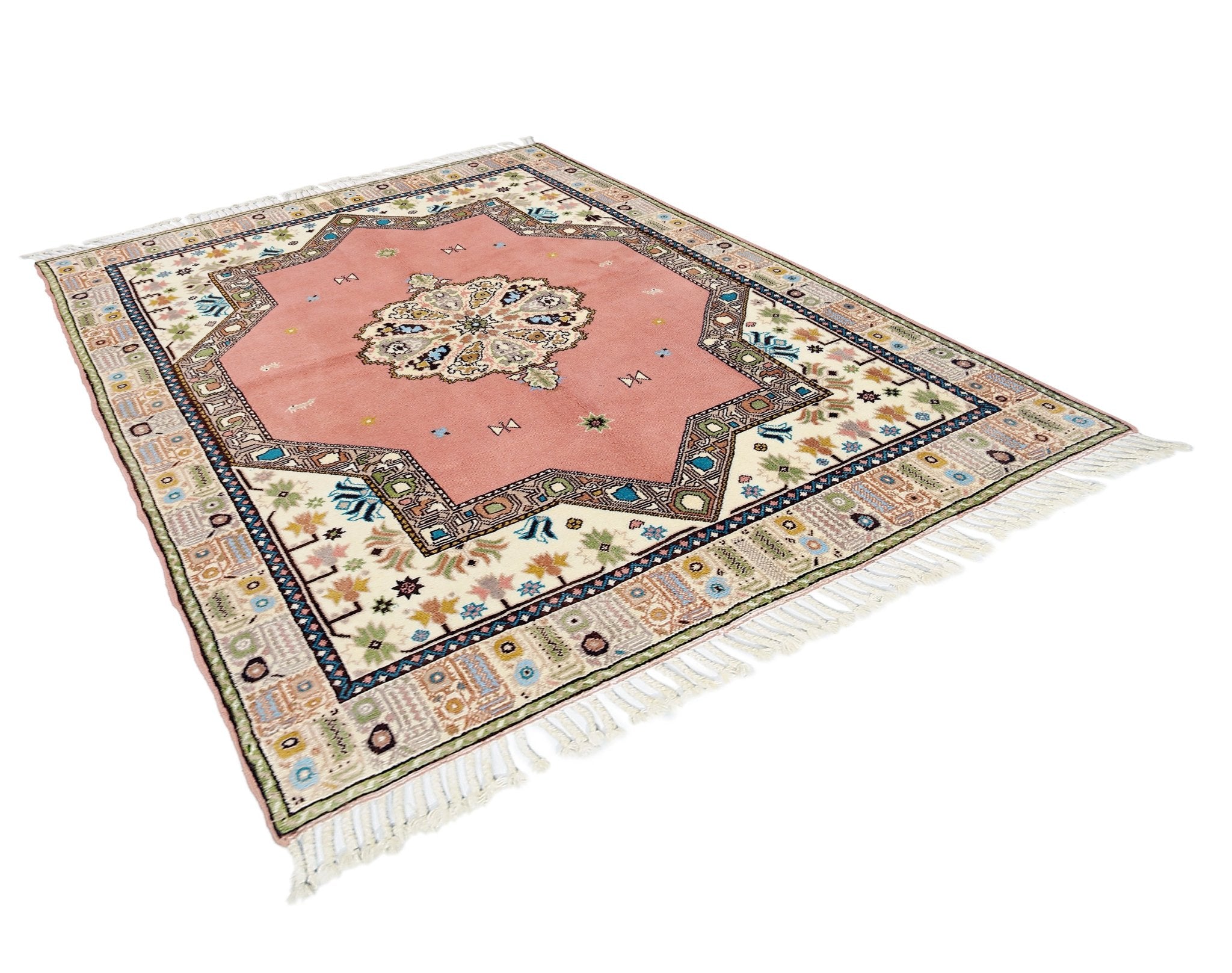 A vintage Turkish Yoruk rug featuring a pink central star medallion on a cream patterned field.
