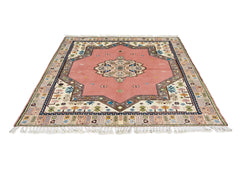 A vintage Turkish Yoruk rug featuring a pink central medallion and intricate geometric borders.