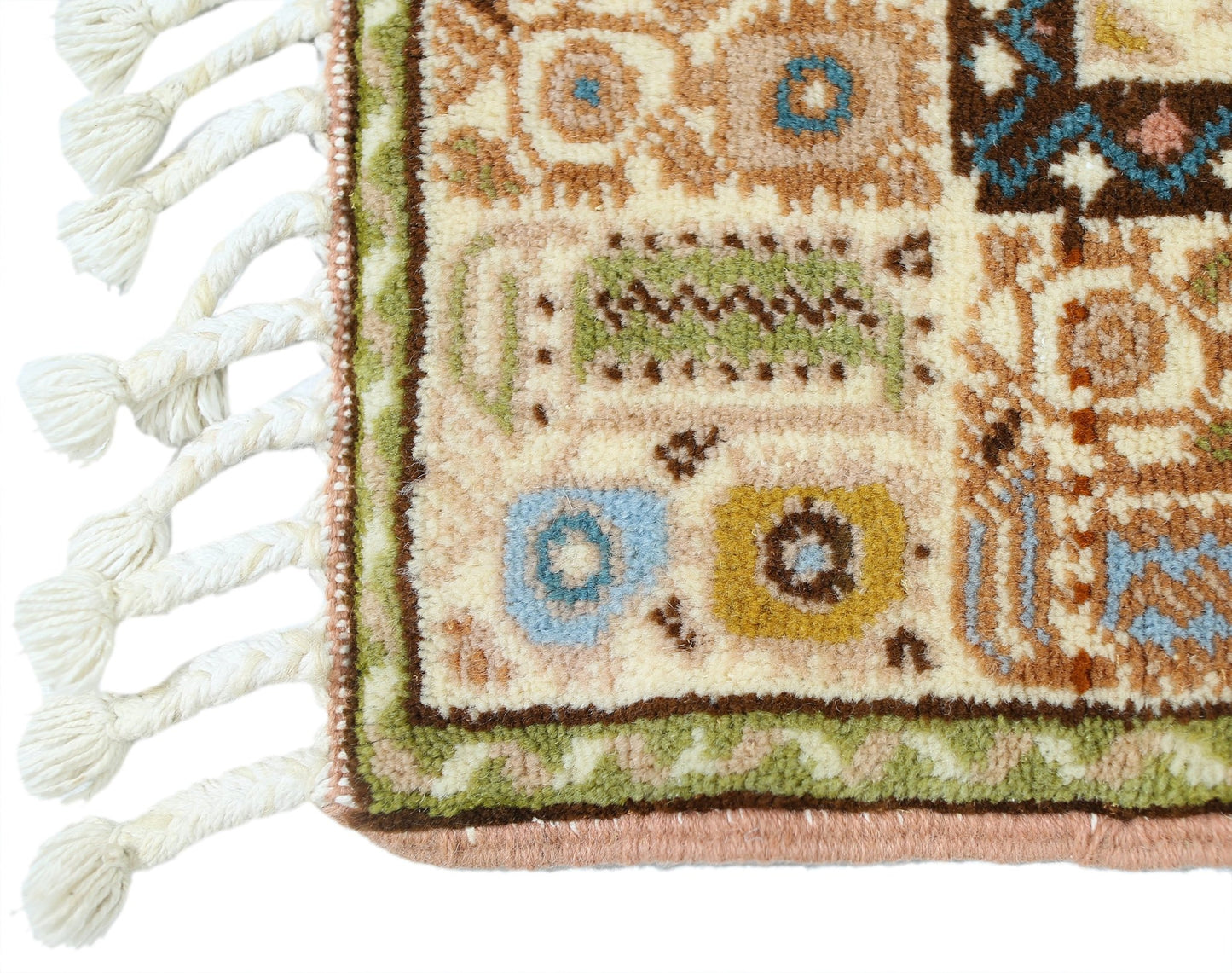 A close-up of a vintage Turkish Yoruk rug featuring geometric patterns in muted tones and a tasseled edge.