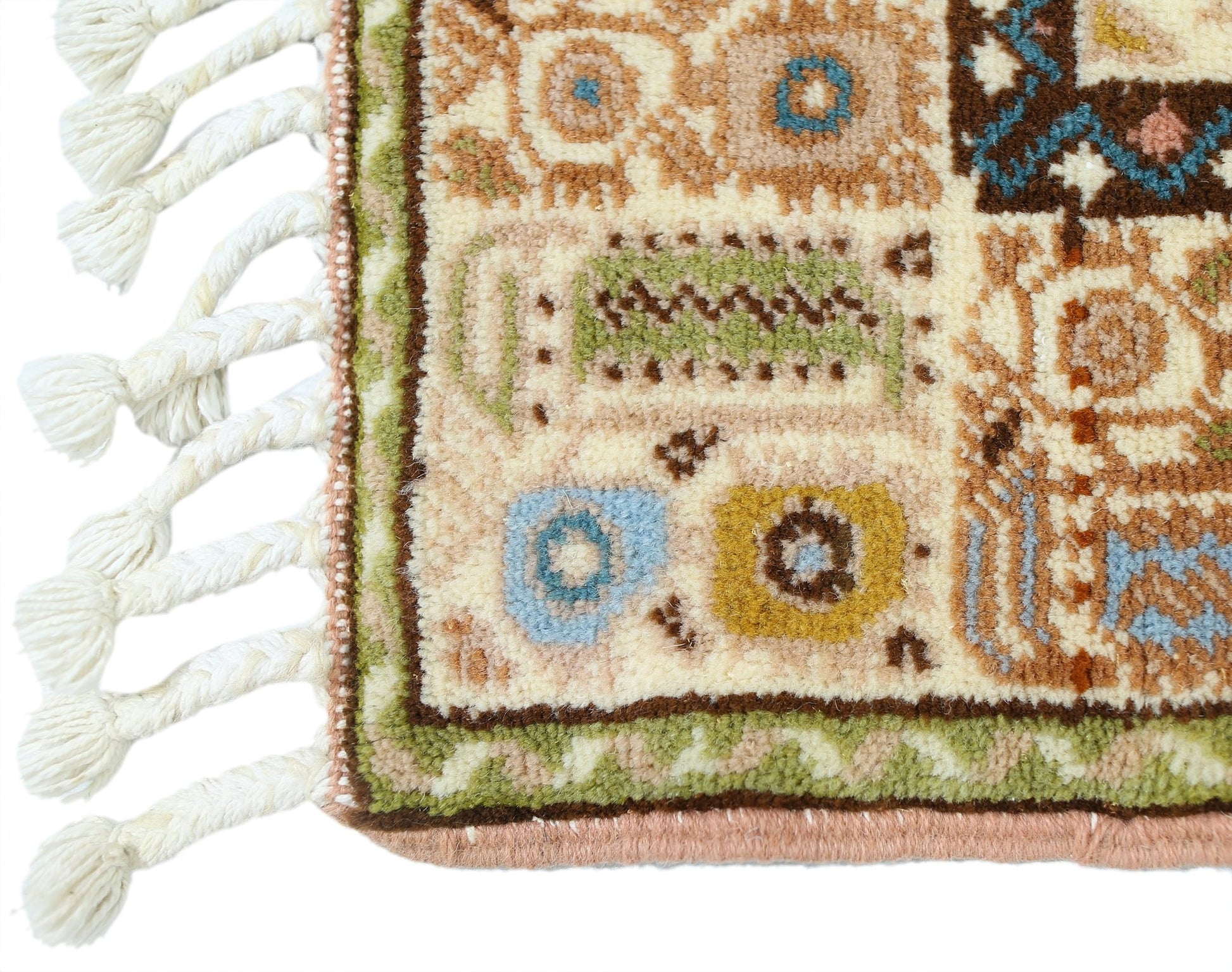 A close-up of a vintage Turkish Yoruk rug featuring geometric patterns in muted tones and a tasseled edge.