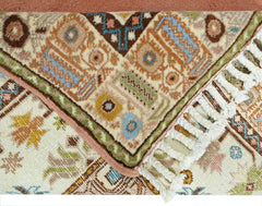 A vintage Turkish Yoruk rug featuring geometric patterns in muted earth tones with a fringed edge.