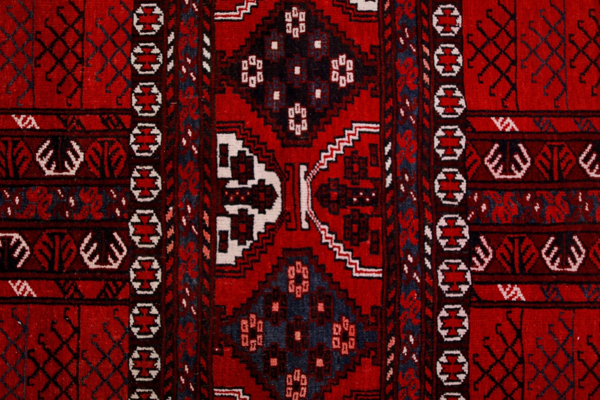 A vintage Afghan Turkmen Engsi rug featuring geometric patterns in red, blue, and ivory.
