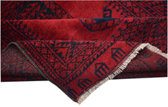A vintage Afghan Turkmen rug featuring a deep red field with dark geometric elephant foot motifs.