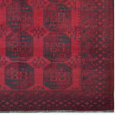 A vintage handmade Afghan Turkmen rug featuring dark geometric octagonal motifs on a red field.