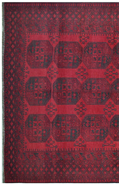 A vintage handmade Afghan Turkmen rug featuring dark geometric octagons on a deep red background.