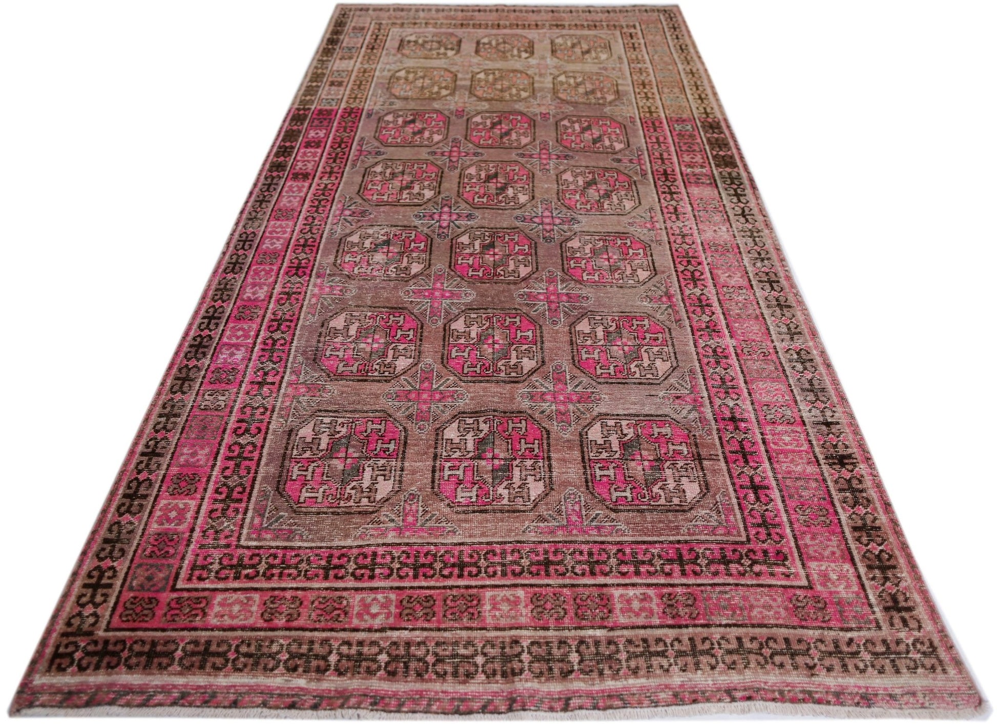 An antique handwoven Afghan Turkmen rug featuring a repeating pomegranate pattern in vibrant pink.