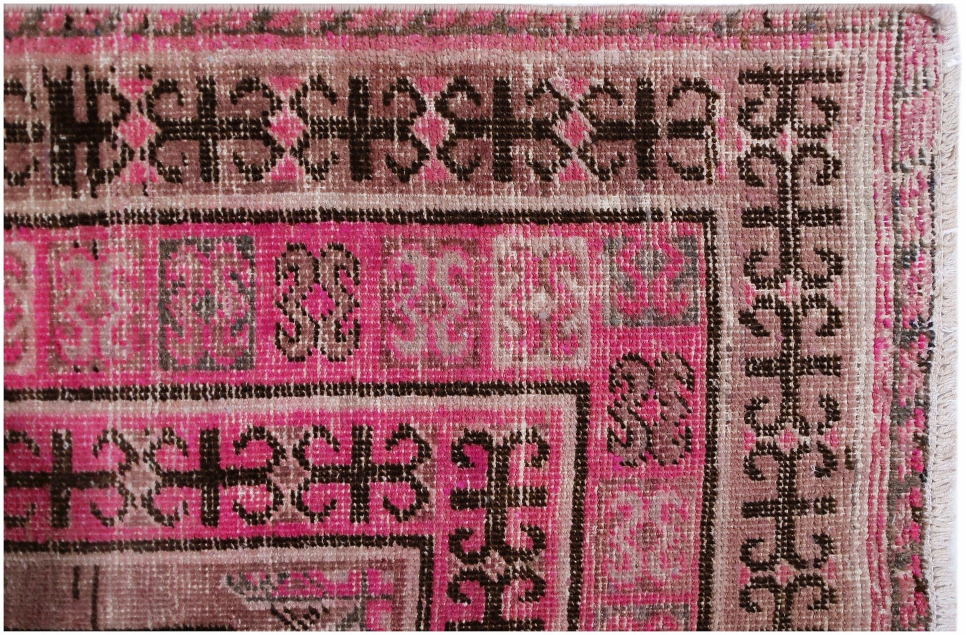 An antique handwoven Afghan rug featuring an intricate pomegranate pattern in vibrant pink.
