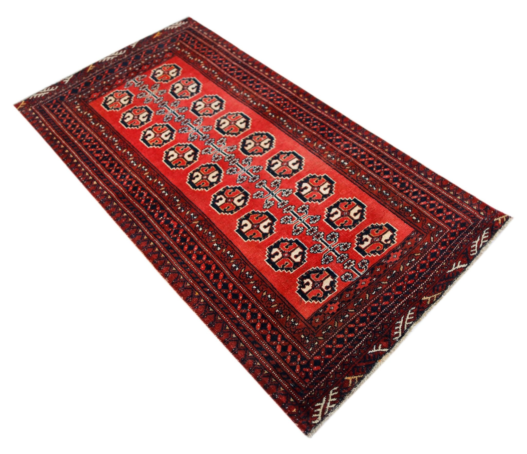 A vintage handmade Afghan Baluch rug featuring a red field with repeating geometric motifs.