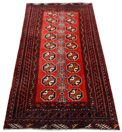A vintage handmade Afghan Baluch rug featuring a red field with repeating geometric motifs.