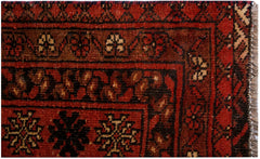 A vintage handwoven Afghan Turkmen rug featuring traditional geometric patterns in red and black.