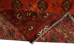 A handwoven vintage Afghan Turkmen rug featuring traditional geometric patterns in deep red and brown.