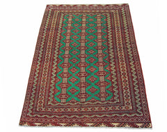 A vintage Persian Turkmen rug featuring a repeating diamond pattern in red and green.