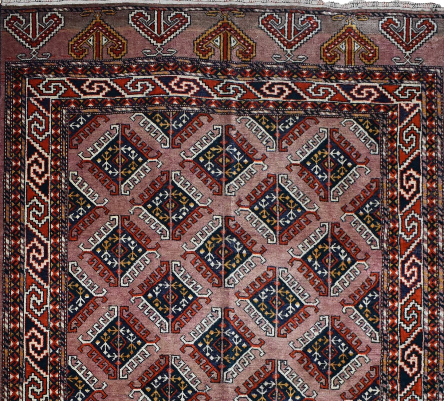 A vintage handmade Uzbek Bokhara wool rug featuring a repeating geometric diamond pattern in red and blue.